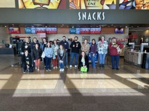 Group of adults posing in front of a snack bar.